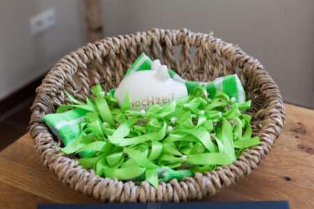 Grüne Gastgeschenke im braunen Weidenkörbchen, liebevoll arrangiert für eine nachhaltige Hochzeit